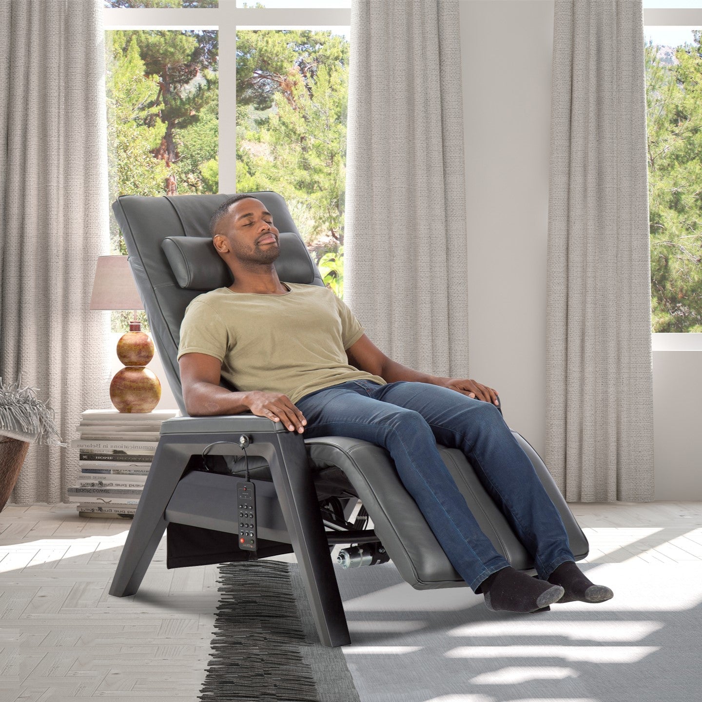 Gravis ZG Chair in zero gravity position with person relaxing in sunlit room near window with white curtains