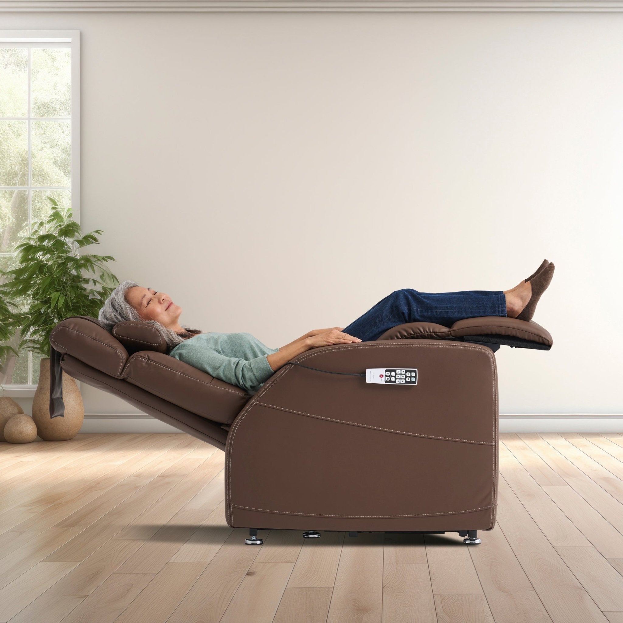 Laevo ZG Chair with Lift Assist in brown leather, fully reclined position with heated massage controls shown in home setting