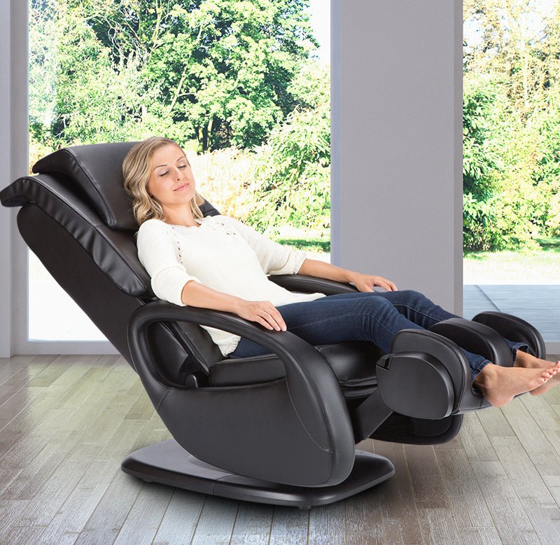 Person relaxing in WholeBody 5.1 Massage Chair with FlexGlide technology, showing full recline position against nature view